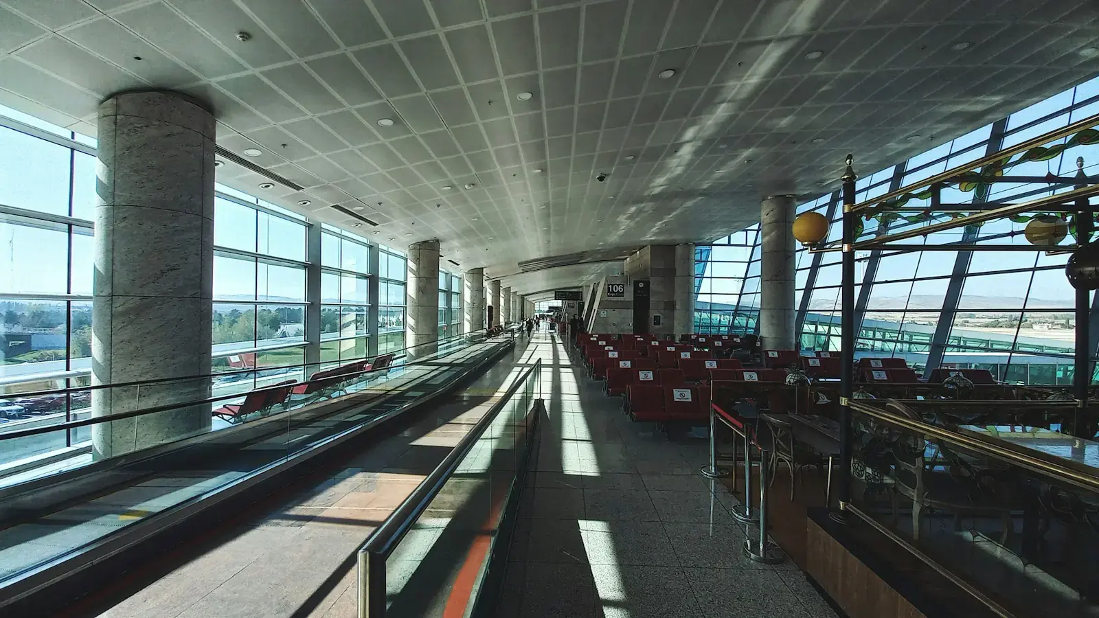 Un luminoso pasillo de aeropuerto con luz que entra por las ventanas
