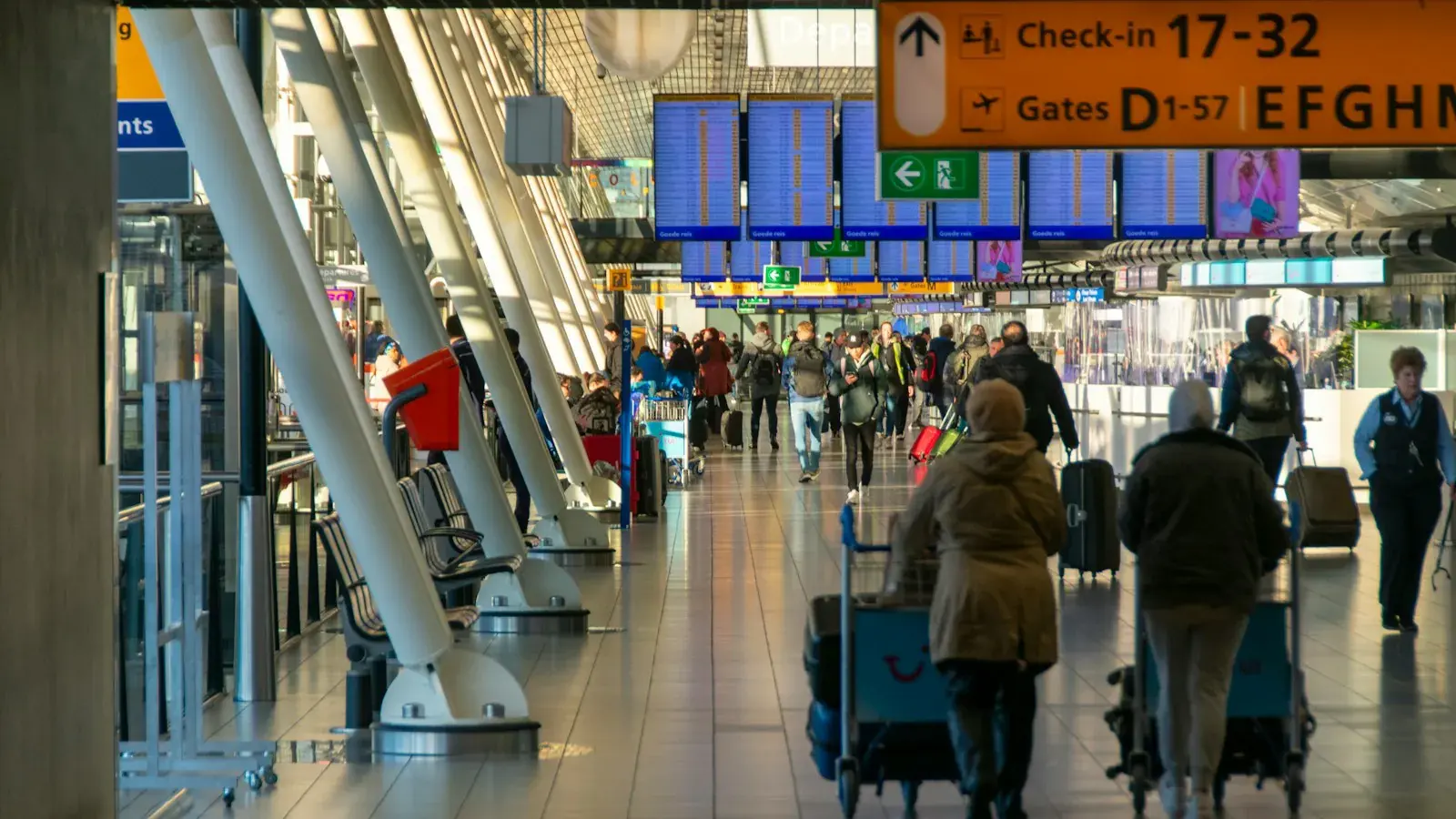 空港のチェックインのホールを歩く人たち