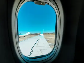飛行機の窓から見える翼と空